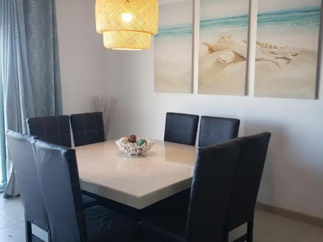 The apartment’s dining room with a table for six and beach pictures