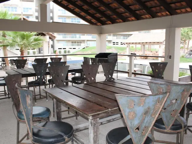 The condominium’s palapa with tables and tall wooden chairs