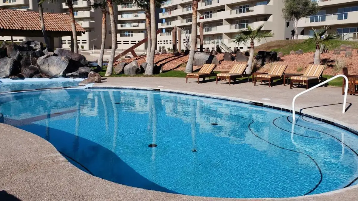 Outdoor pool at the Corona del Sol condominium, with sun loungers and palm trees